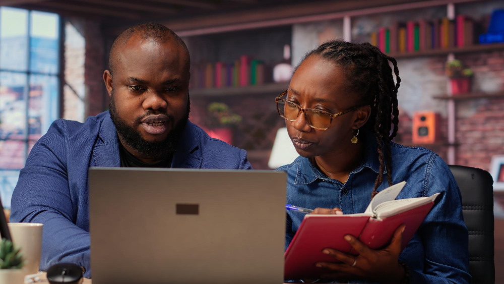 Two Academy participants working through a lesson on a laptop