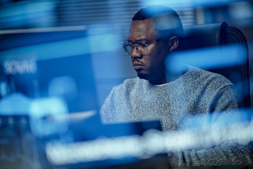 A Tranarc engineer working at a screen in a dark studio